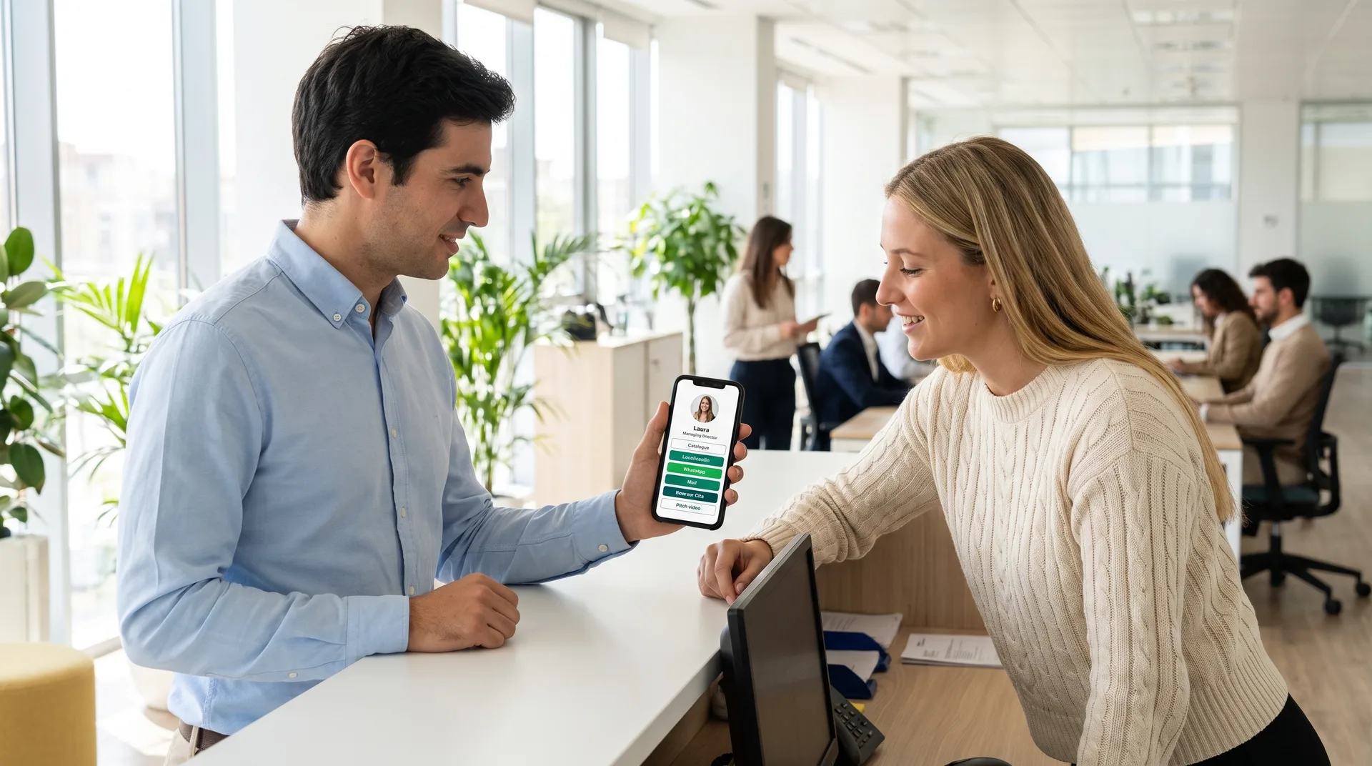 Na receção de um escritório, um colaborador partilha o seu cartão digital a partir do telemóvel com uma visita